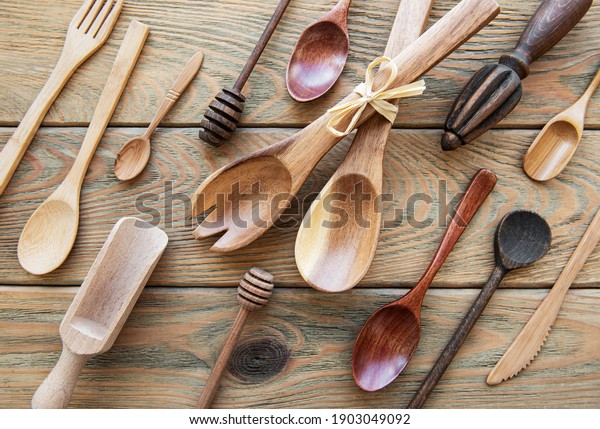 Top view on a wooden cutlery kitchen  ware on a \
old wooden background, flat\
lay