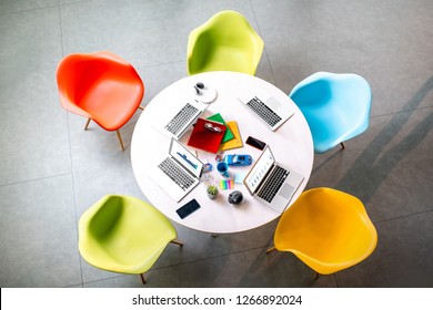 Top View On The Working Place With Round Table And Colorful Chairs In The Office