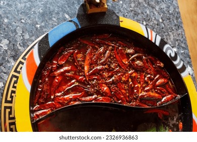 Top view of one part very spicy chili pepper soup in a hot pot. - Shutterstock ID 2326936863