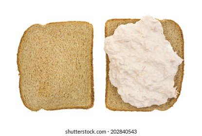 Top View Of An Open Faced Tuna Sandwich On Whole Wheat Bread Atop A White Background.