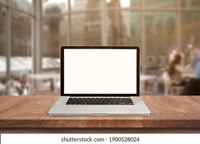 Top view of Open laptop blank screen or notebook isolated on wooden table in soft blurry restaurant background. of free space for your copy, view from top.