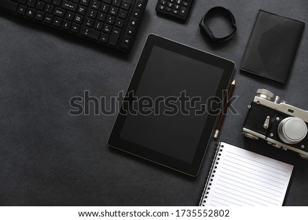 Top view of an open notebook with stationery items. Photographer's desk. Film camera and lenses.