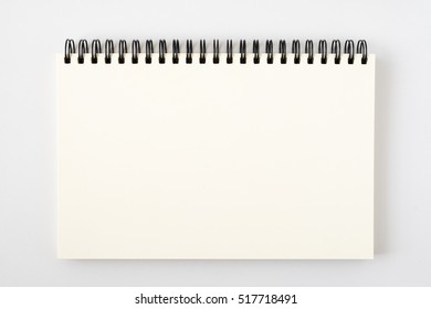 Top View Of Open Spiral Blank Notebook With Pencil On White Desk Background