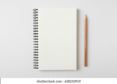 Top View Of Open Spiral Blank Notebook With Wood Pencil On White Desk Background