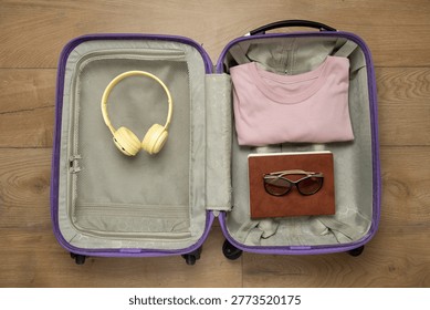 Top view of open suitcase packed with travel essentials ready for vacation and trip preparation.