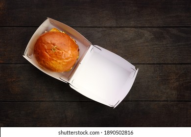 Top View Of Open Take Away Box With Burger On Wooden Table