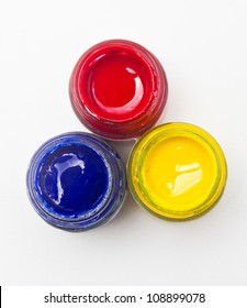 Top View Of Opened Bottles Of Primary Color On White Background.