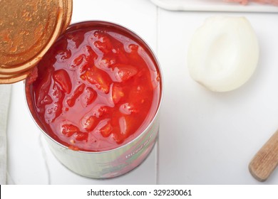 A Top View Of Opened Can Of Diced Tomatoes On White Table