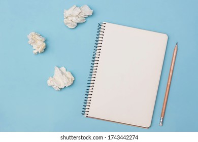 Top view opened notebook and beige pencil   pieces crumpled paper near it blue desk background  Back to school  Business education concept  Flat lay  Copy space 