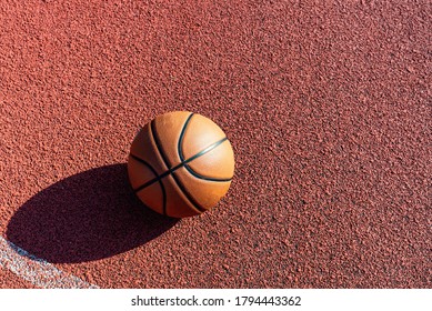 Top view orange ball for basketball lying on the rubber sport court.Sport red ground outdoor in the yard.Copy space - Shutterstock ID 1794443362
