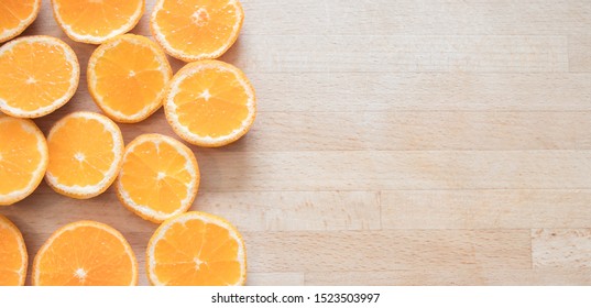 Top View Of Orange Slices On Butcher Block With Space For Text.