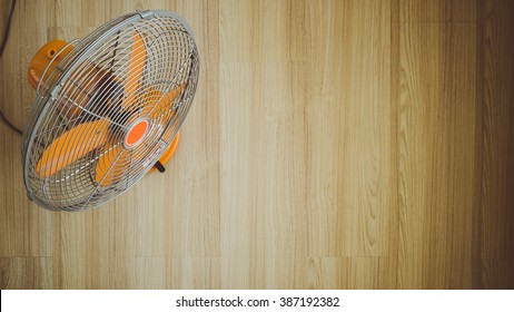 Top View Orange Vintage Fan On Wooden Floor.