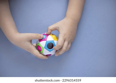 Top view of orbo puzzle ball in kid's hands on the blue background