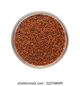 Top view of Organic Small Orange Brown Mustard Seeds (Brassica juncea) in glass bowl isolated on white background.