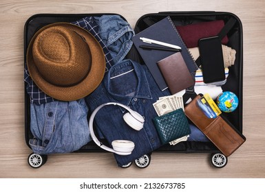 Top view Organize luggage. Put clothes and pants in trolley bag and prepare to go abroad. Preparing suitcase for summer vacation trip. Traveler accessories open luggage.