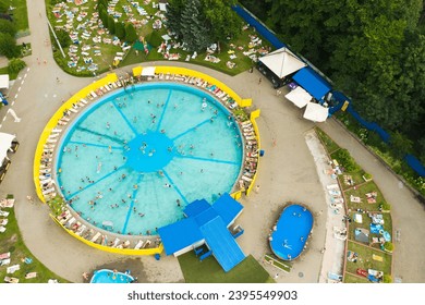 Top view of an outdoor place for people to relax where there is a swimming pool and a lot of sun beds. - Shutterstock ID 2395549903