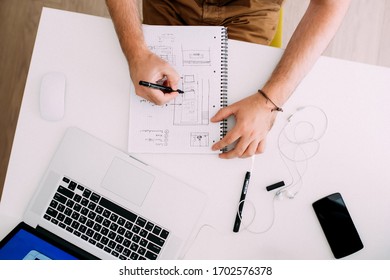 Top View Over Hands Of A Man Working At The Computer / Laptop, Taking Notes, On White Table Background.