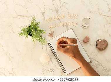 Top view over marble table top, writing out dreams to manifest