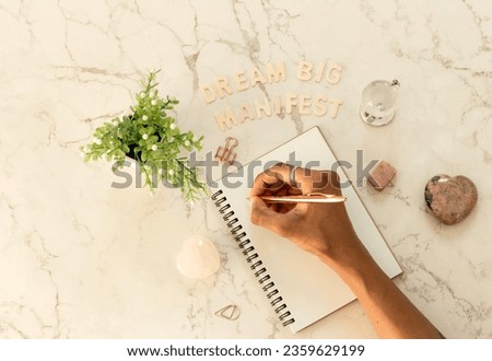 Top view over marble table top, writing out dreams to manifest