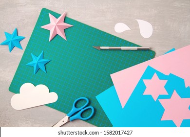 Top View Over Paper  Cut Tools, Scissors, Cutter, Cutting Mat, And Crafted Paper Objects. DIY Trendy Project Concept. Flat Lay