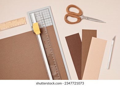 Top view over paper cut tools, scissors, cutter, cutting mat, and crafted paper objects. DIY trendy project concept. Flat lay - Powered by Shutterstock