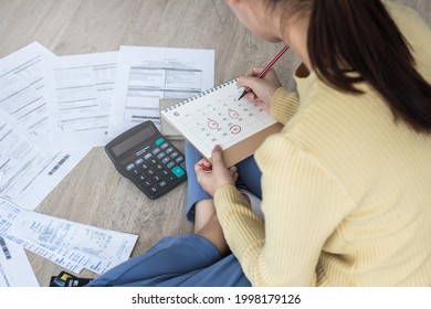 Top view owe, mortgage asian woman, female sitting on floor home, stressed calculate expense from bills, no money pay in mark circle deadline on calendar.Debt, bankruptcy or bankrupt person concept.