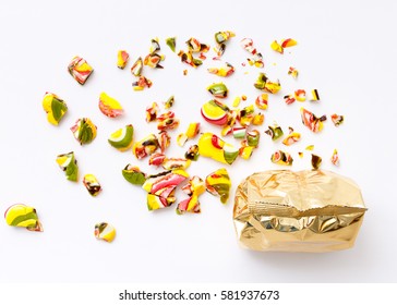 top view of packaged various chocolate pralines and roughly broken lollipops on white background. Sweet sucker, lollipop, candy, minimal concept above decoration, food background
