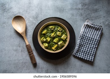 Top View Of Palak Paneer Or Cottage Cheese Cubes In Spinach Curry With Use Of Selective Focus On A Particular Cottage Cheese Cube With Rest Of The Cubes And Everything Else Blurred. 