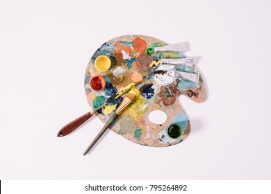 top view of palette with colorful paints isolated on grey 
