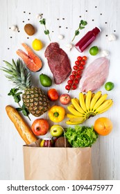 Top View, Paper Bag Of Health Food On A White Wooden Background. From Above, Flat Lay. Healthy Eating Concept.