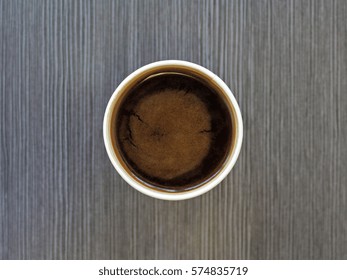 Top View Of A Paper Cup Of Black Brewed Coffee On Wooden Table