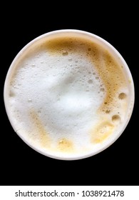 Top View Of A Paper Cup Of Cappuccino Coffee With Milk Foam Isolated On Black Background.