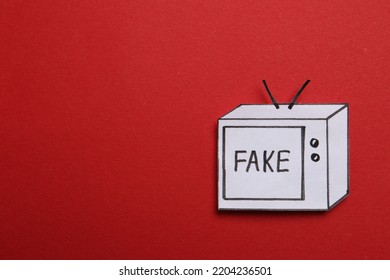 Top View Of Paper TV With Word Fake On Red Background, Space For Text. Information Warfare Concept