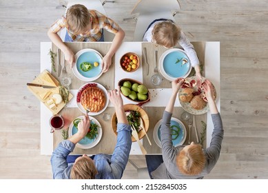 Top View Of Parents And Kids Sitting At Kitchen Table And Having Tasty Lunch Together: Fresh Vegetable Salad, Fruit, Cheese And Homemade Pie
