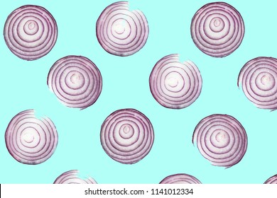 Top view pattern of fresh bright red onion rings on turquoise blue background. Shot from above of multiple sliced onions