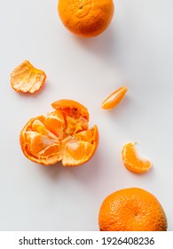 Top View Of Peeled And Whole Tangerine. Peel And Pieces Of Citrus On White Background. Ripe Bright Orange Fruit.