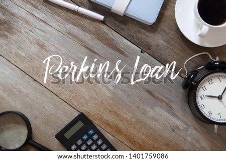 Top view of pen, notebook, coffee, clock, calculator and magnifying glass on wooden background written with Perkins Loan.