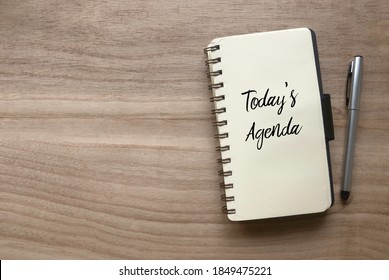 Top view of pen and notebook written with Today's Agenda on wooden background with copy space. - Shutterstock ID 1849475221