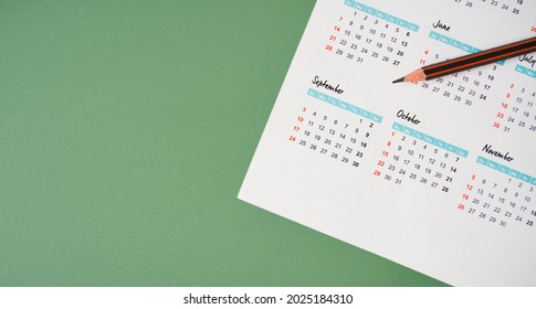 Top View Of Pencil On White Calendar And Green Background For Planning Work ,monthly Or Yearly Schedule , Make Appointment Meeting ,manage Timetable ,routine ,business Project, Timeline Concept