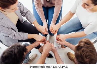 Top View Of People Holding Hands During Group Therapy Session 