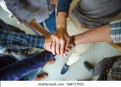 Top view of people joining hands together as a symbol of partnership