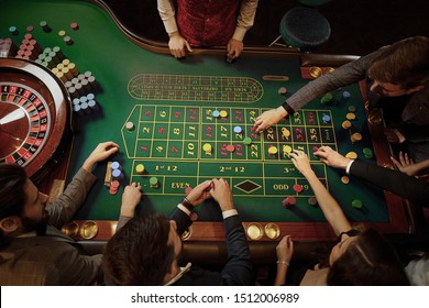Top view of people playing roulette at the table in a casino