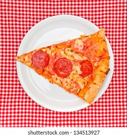 Top View Of Pepperoni Pizza Slice On White Plate Served On Table.