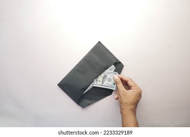 top view of person hand putting cash in a envelope. - Shutterstock ID 2233329189