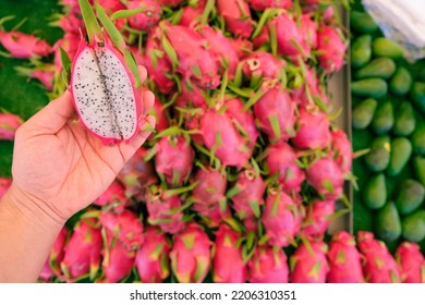 Top View Of Person Holding A Red Dragon Fruit Cut In Half, Pile Of Pitaya, Big Bunch Of Pink Dragon Fruits In Traditional Market, Copy Space.