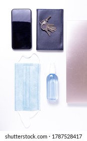 Top View Of A Phone, Wallet, Keys, Mask, Laptop And Antiseptic Spray.