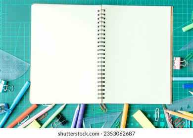 Top view photo, Back to school concept , Flat lay composition with school stationery, Notebook, color pencils, paints, notepad on cutting mat background with copy space for text - Powered by Shutterstock