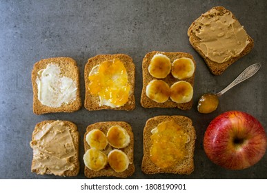 Top View Photo Of Breakfast Table: Apple And Toasts With Different Toppings: Peanut Butter, Jam, Butter And Caramelized Banana. 