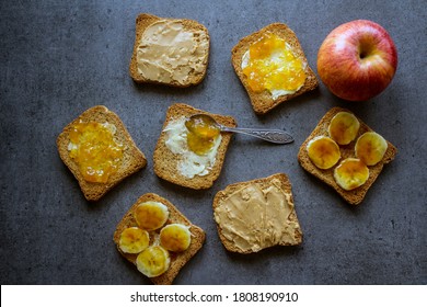 Top View Photo Of Breakfast Table: Apple And Toasts With Different Toppings: Peanut Butter, Jam, Butter And Caramelized Banana. 