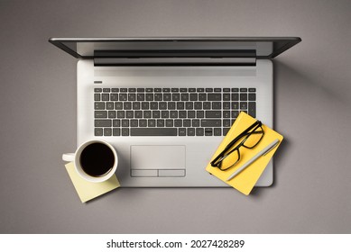 Top view photo of cup of drink on yellow sticker note pen glasses and yellow organizer on open grey laptop on isolated grey background